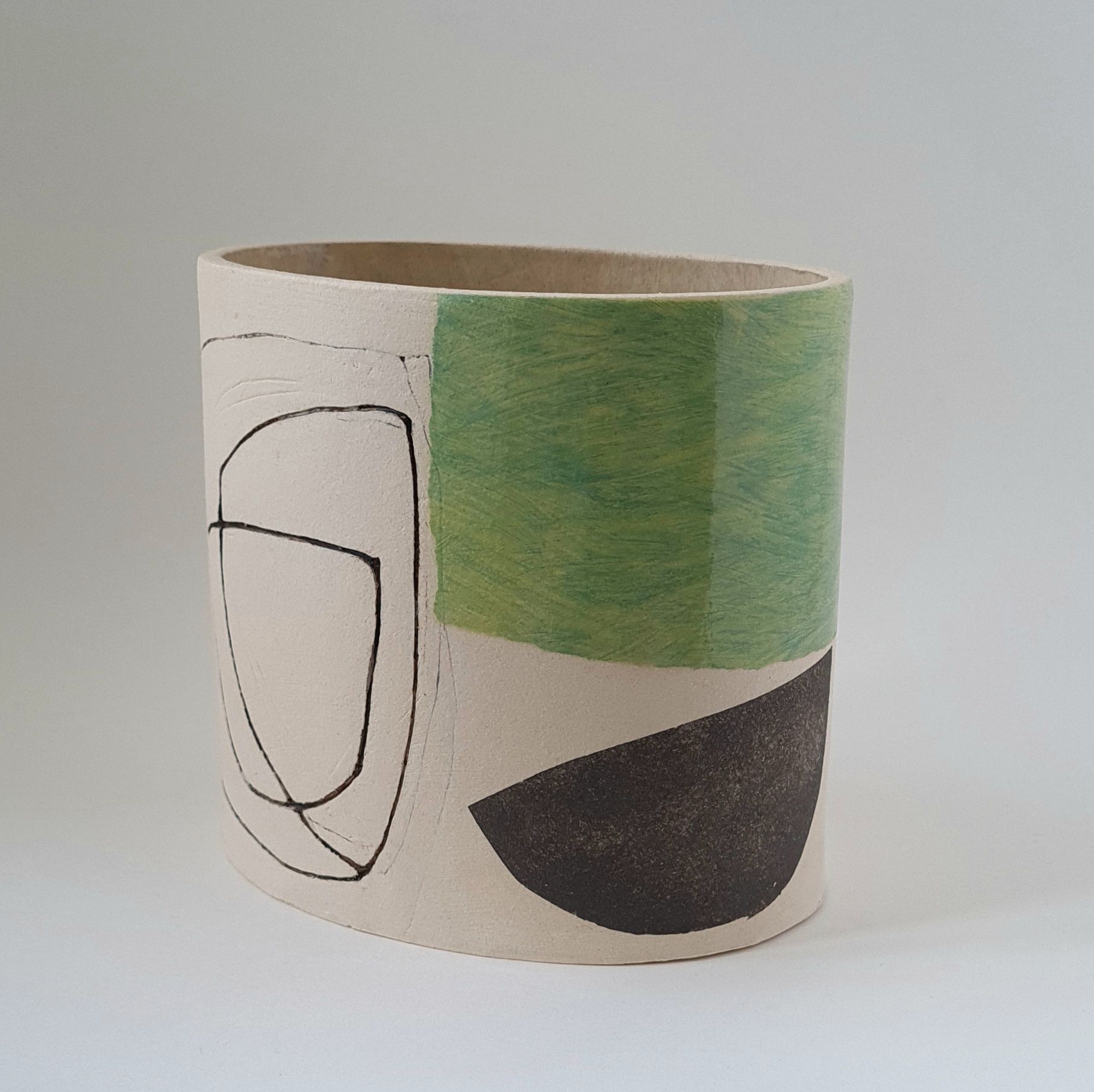 a white vase with a green and black design on it