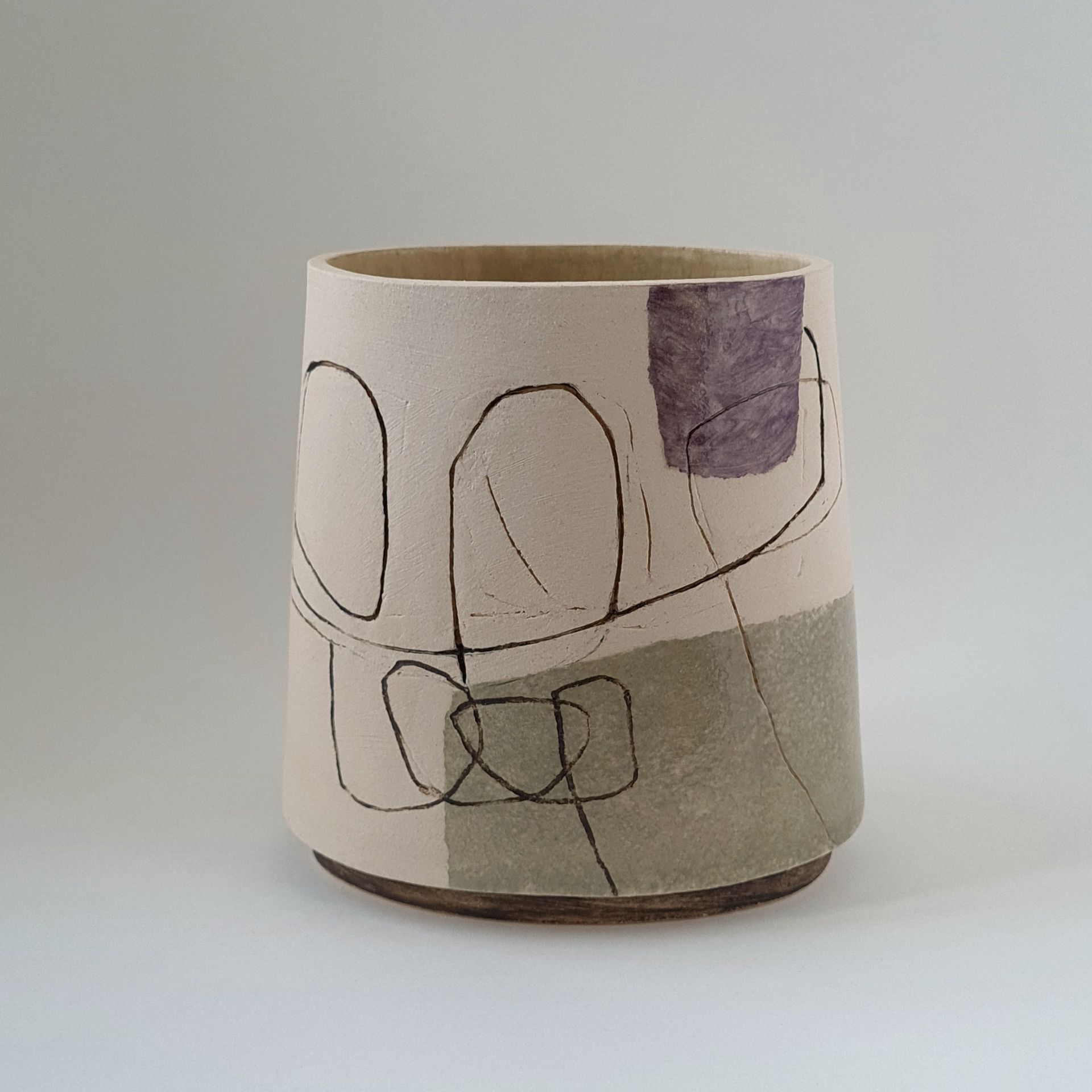 a vase with an abstract drawing  on it