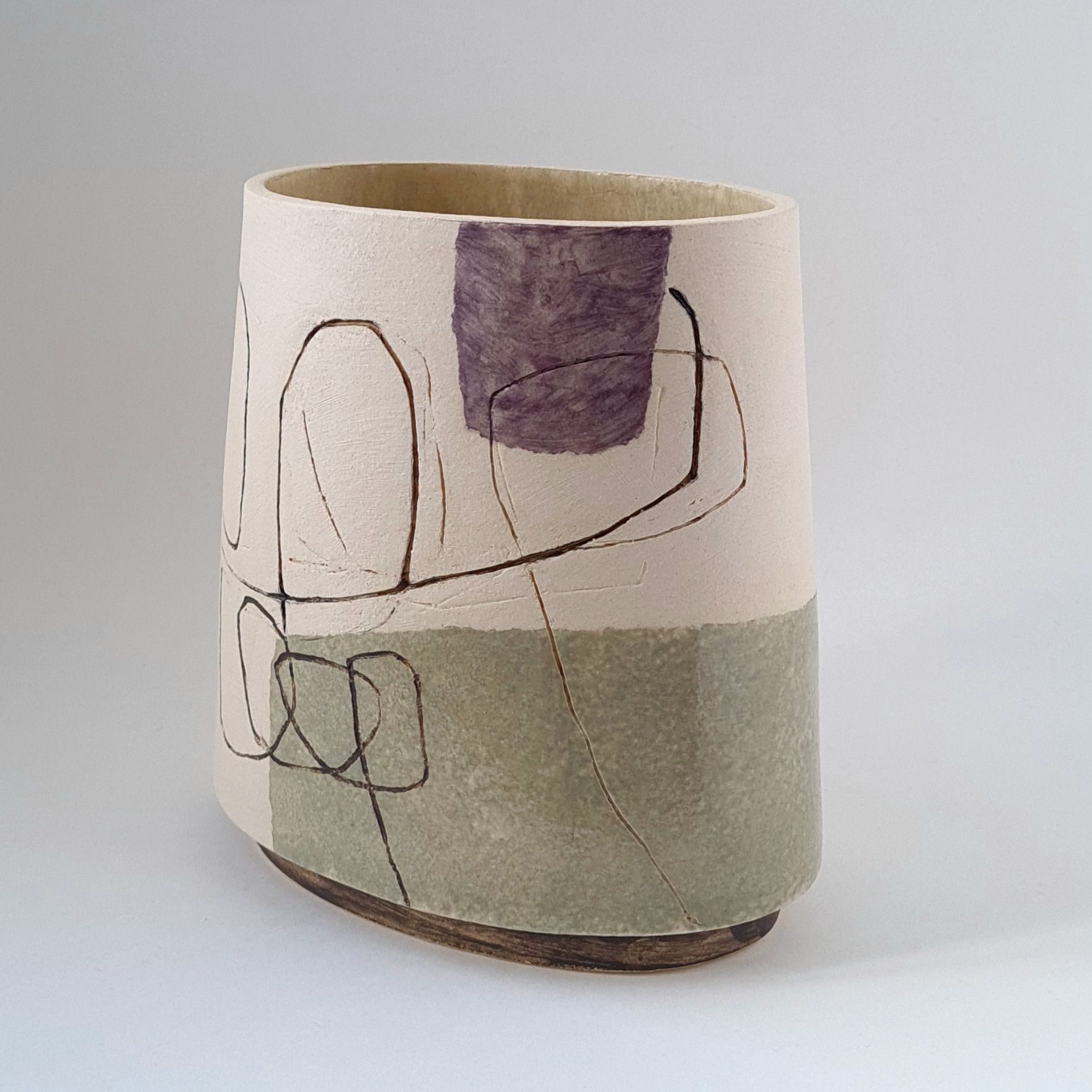 A vase with a purple and green design on it