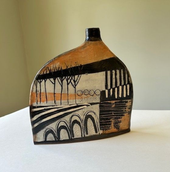 A ceramic vase with trees and arches on it