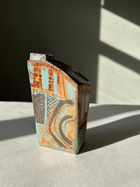 A small ceramic vase is sitting on a table.