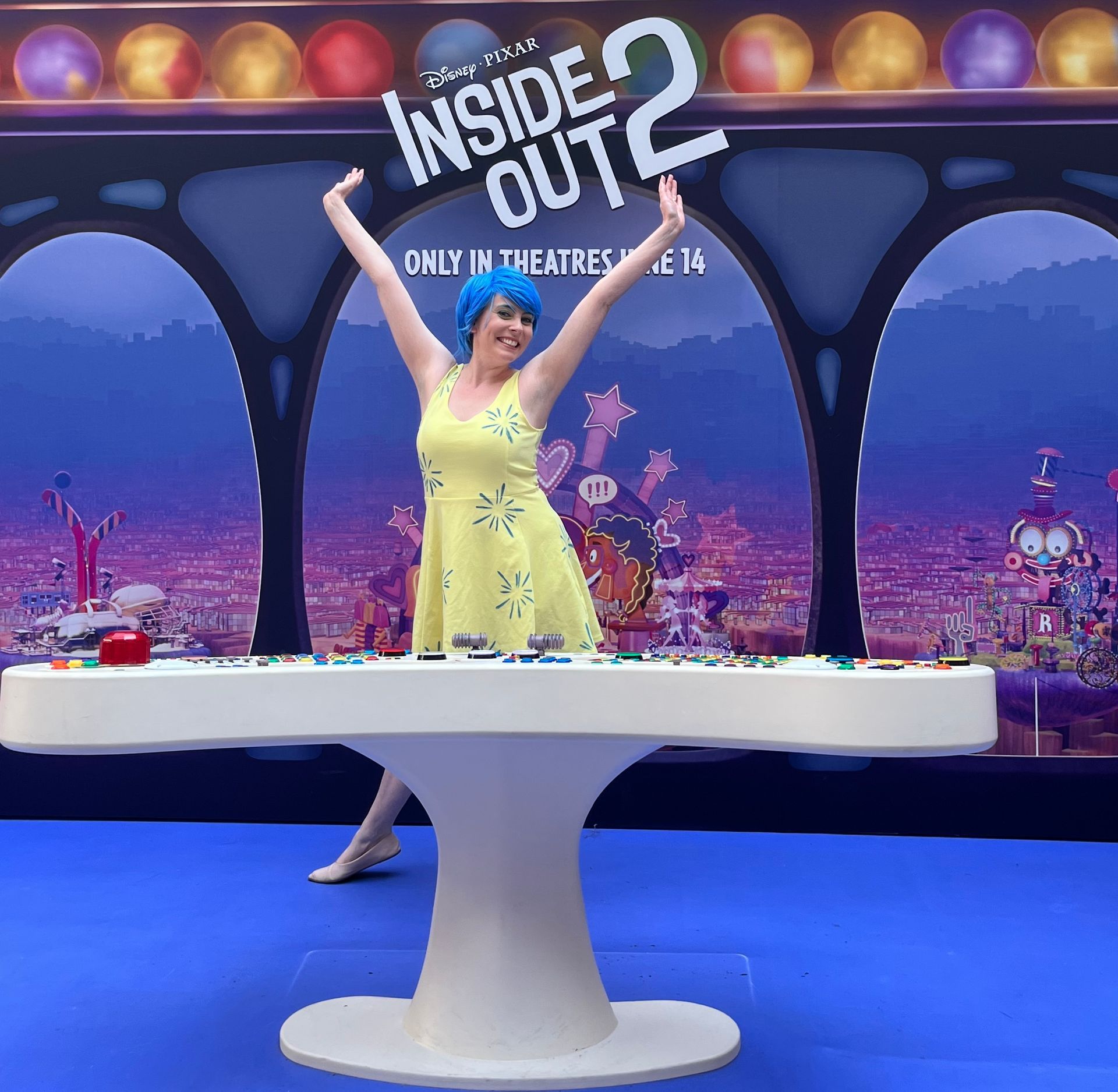 A woman stands in front of a sign that says inside out 2
