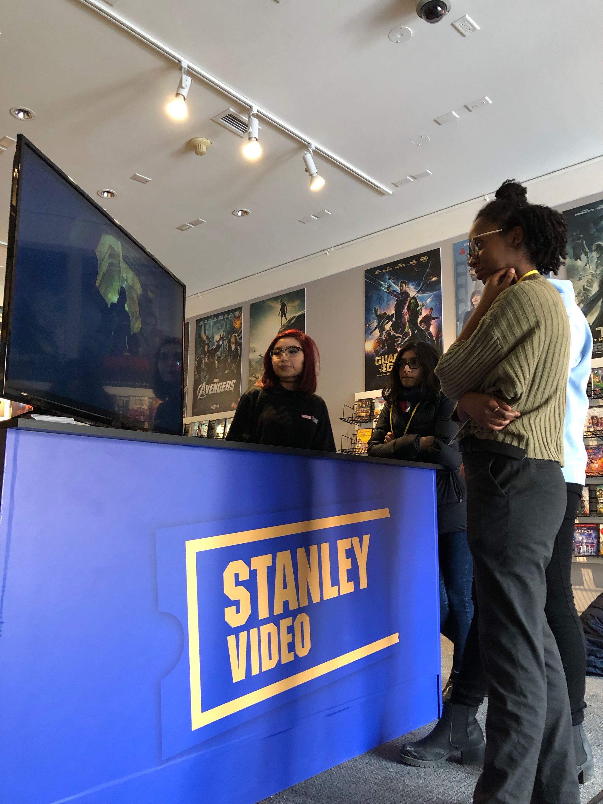 A group of people standing in front of a stanley video counter