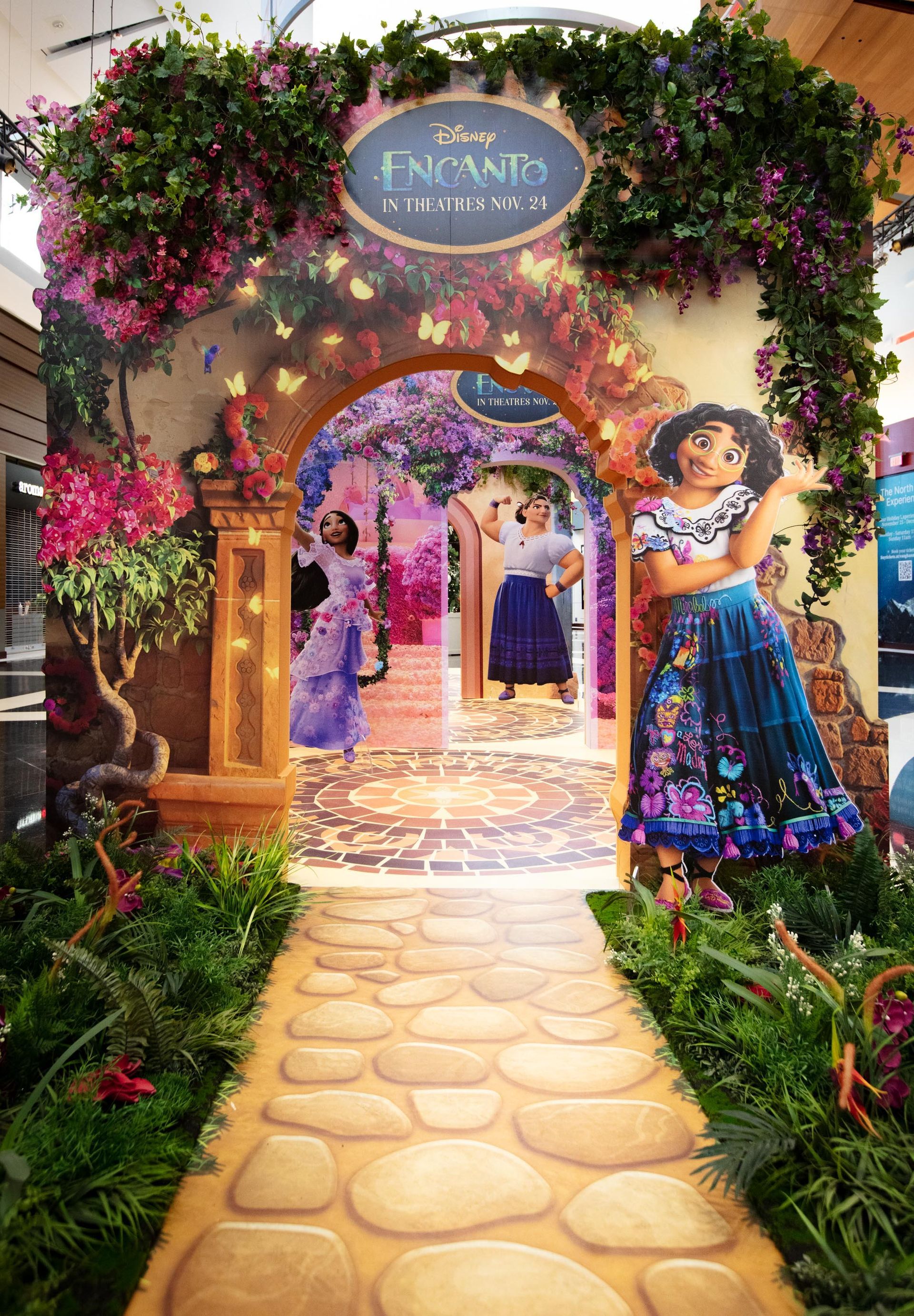 A painting of a woman standing in front of a doorway surrounded by flowers.