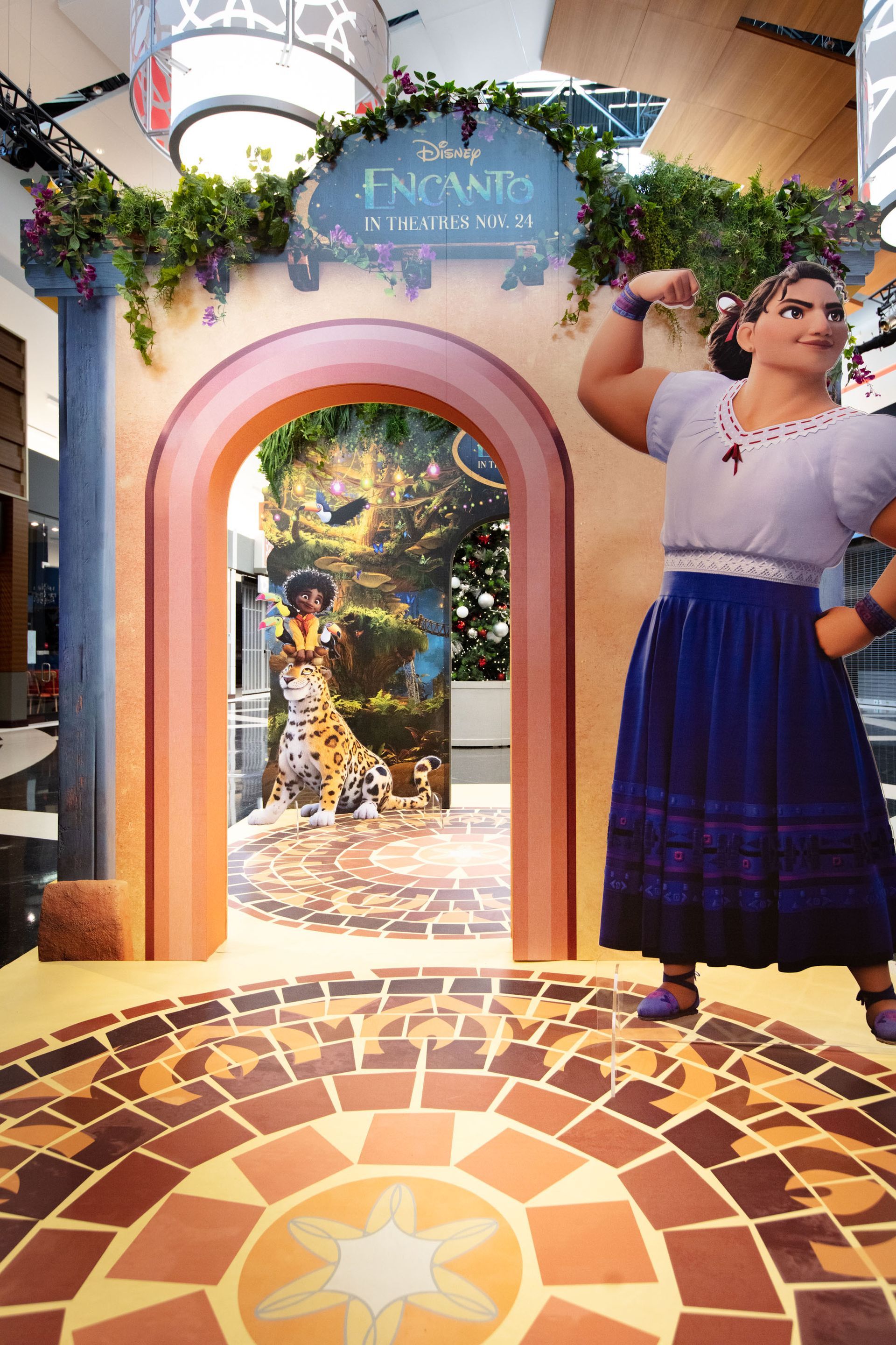 A statue of a woman in a blue skirt is standing in front of an archway.