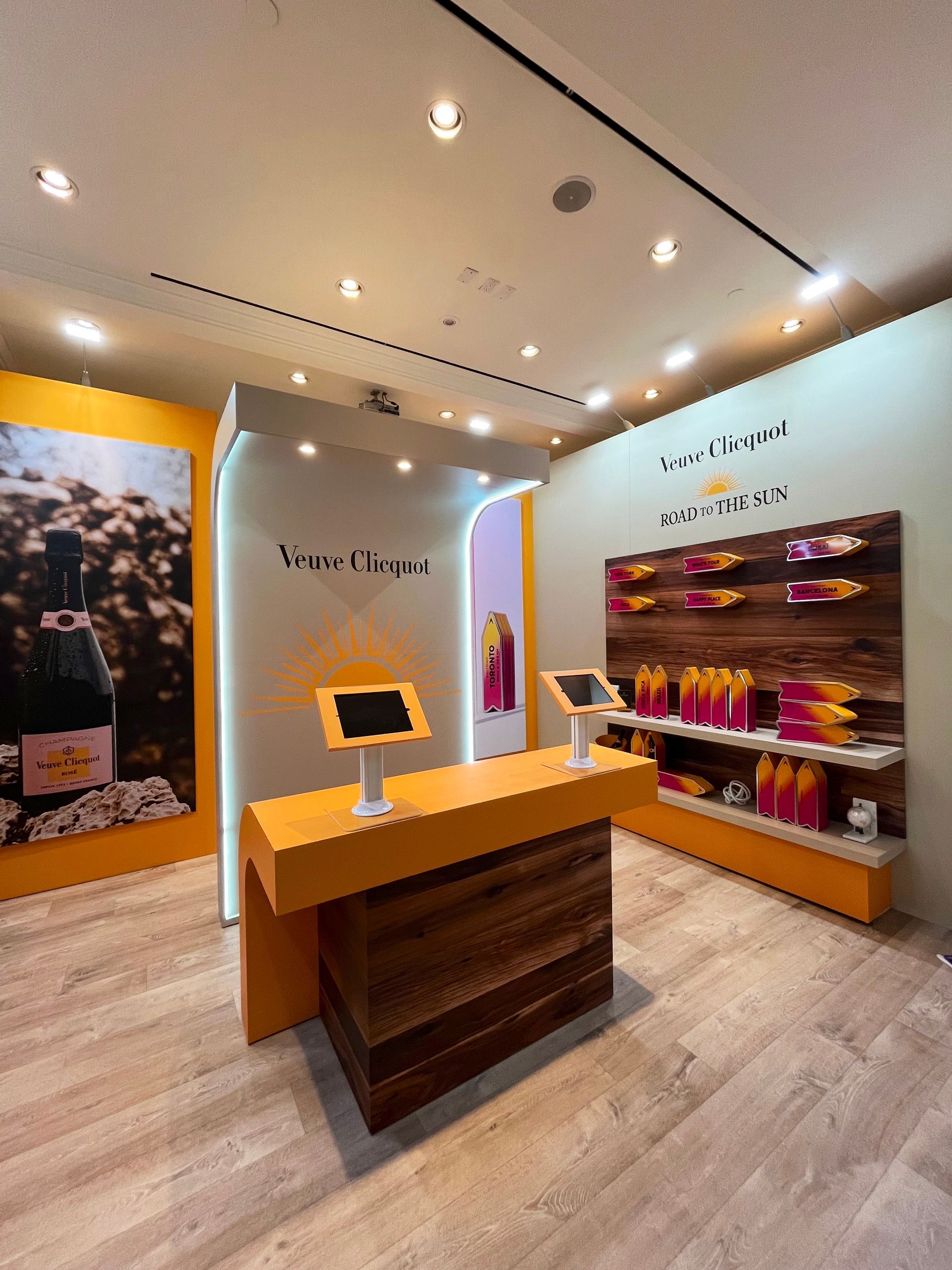 A room with a wooden table and a display of wine bottles on the wall.