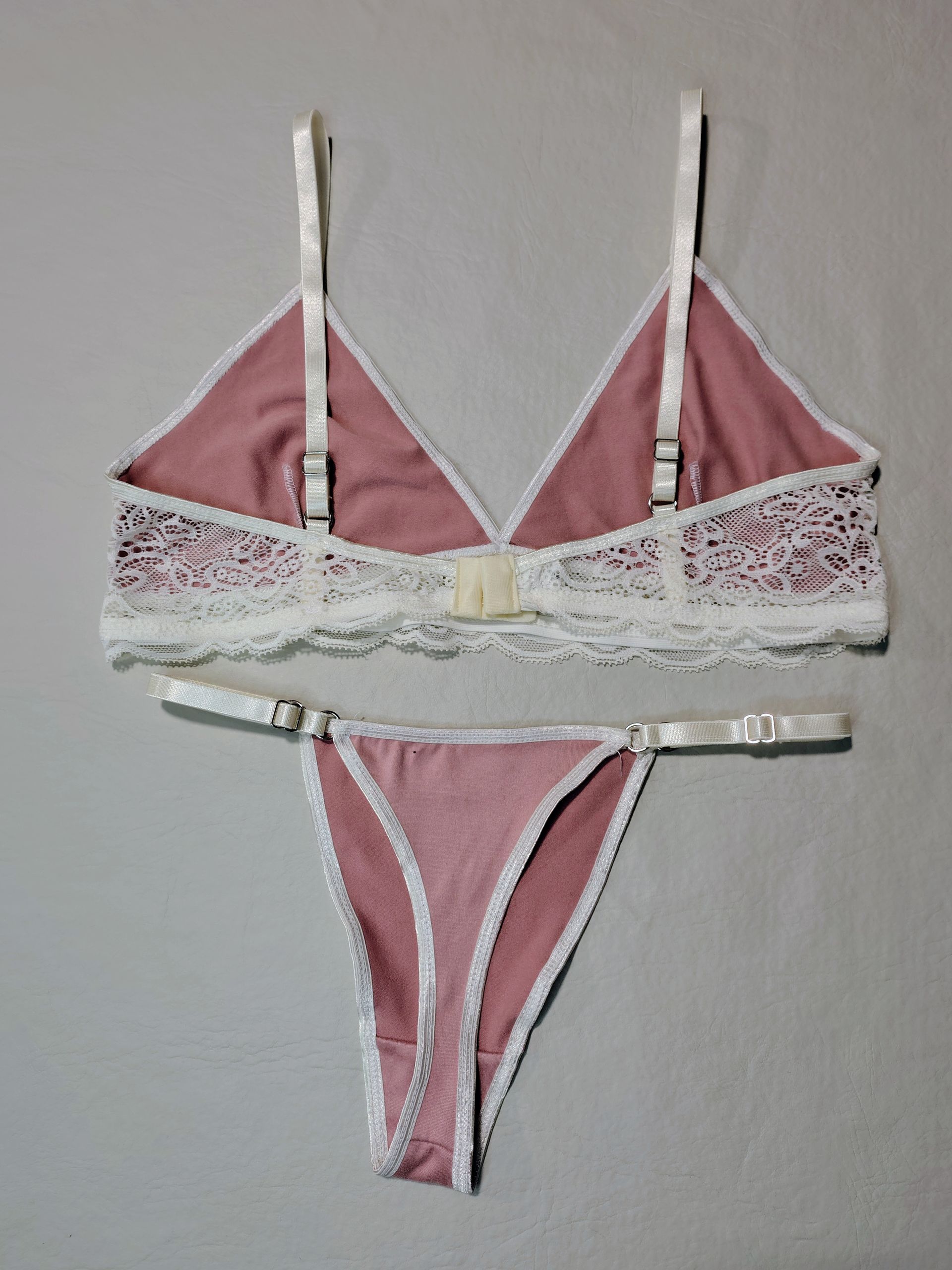 Conjunto de lencería rosa con ribete de encaje blanco.
