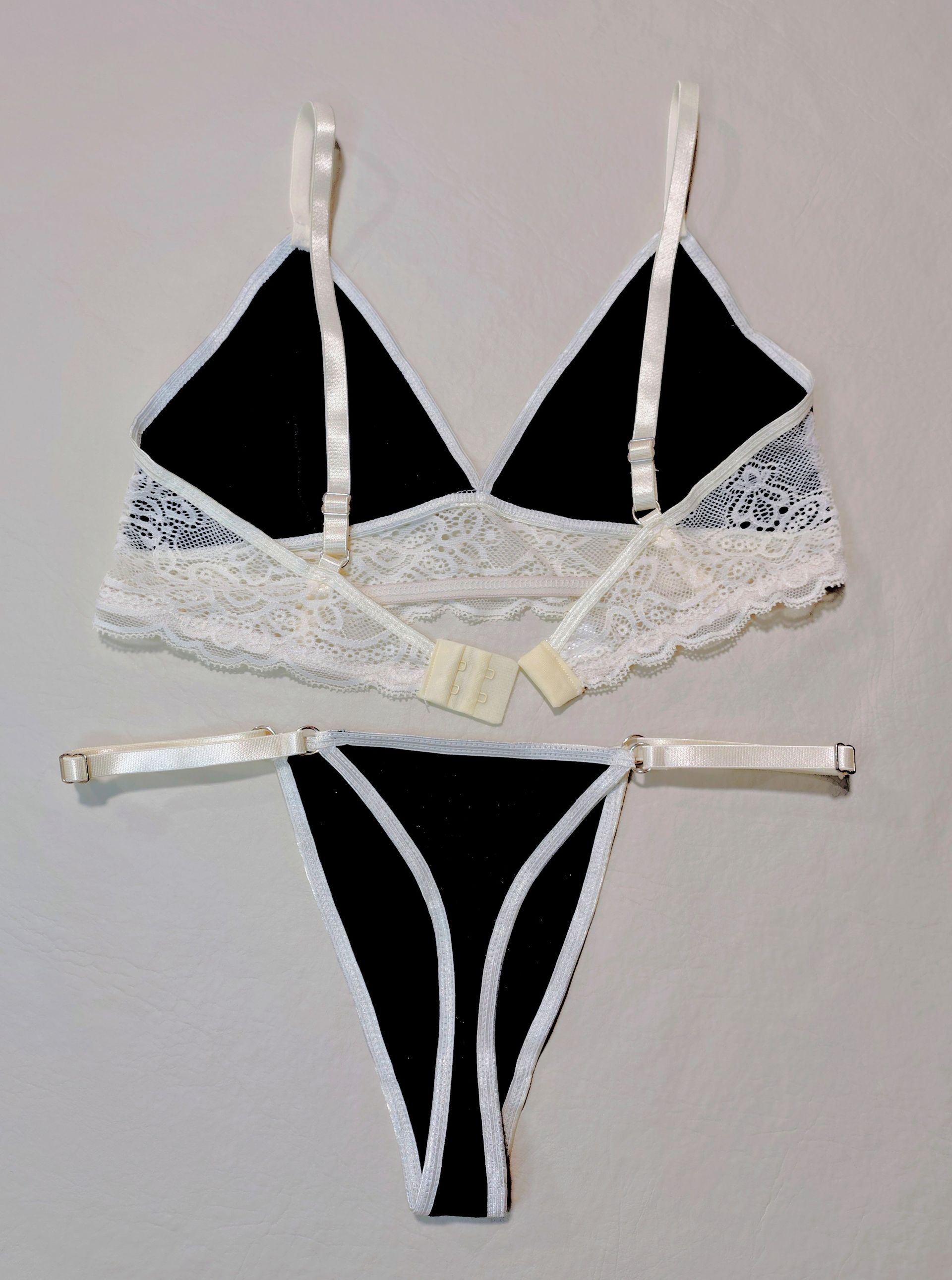 Conjunto de lencería en blanco y negro con sujetador triangular y tanga, adornado con encaje.