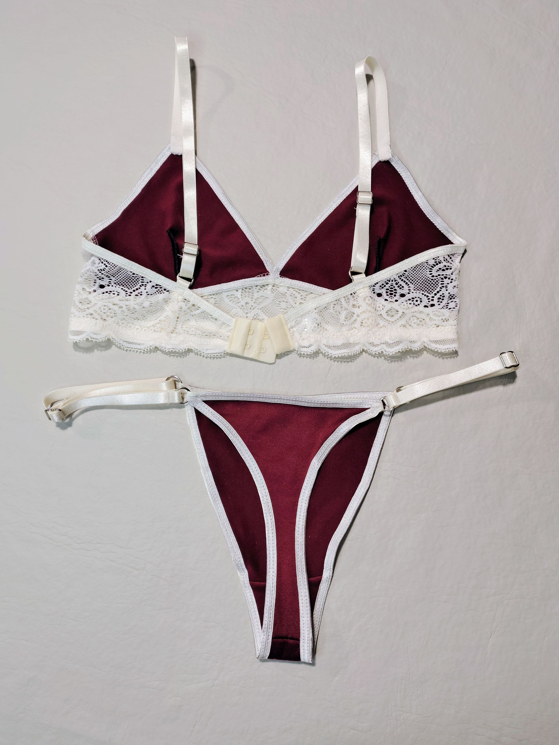 Conjunto de lencería de satén burdeos con ribete y tirantes de encaje blanco.