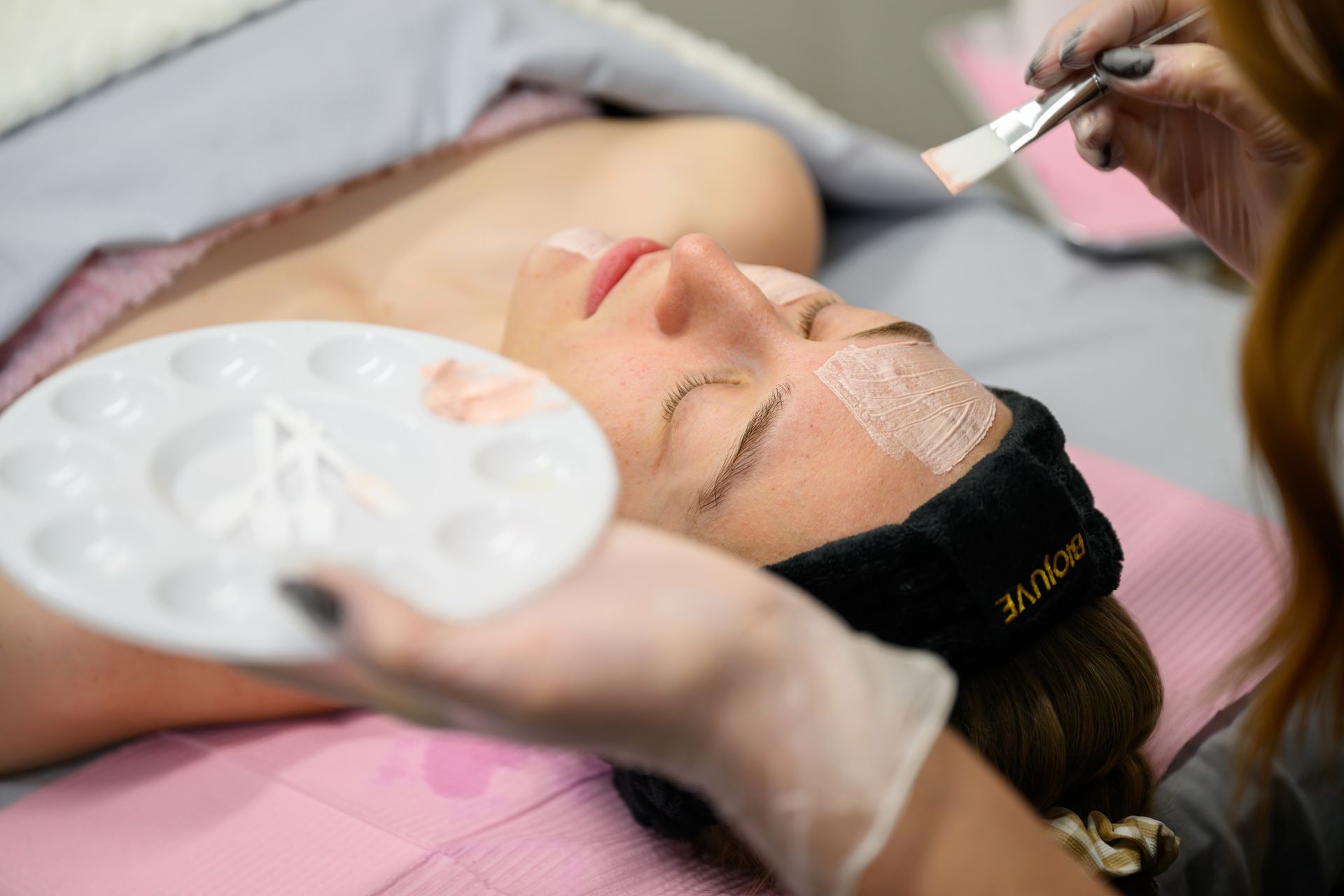 A woman is getting a facial treatment at a spa.