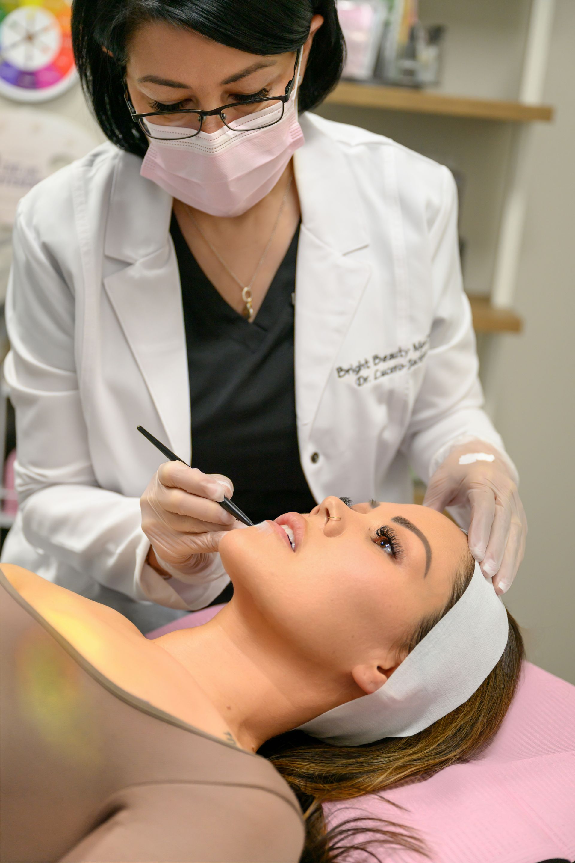 A woman is getting a facial treatment from a doctor.