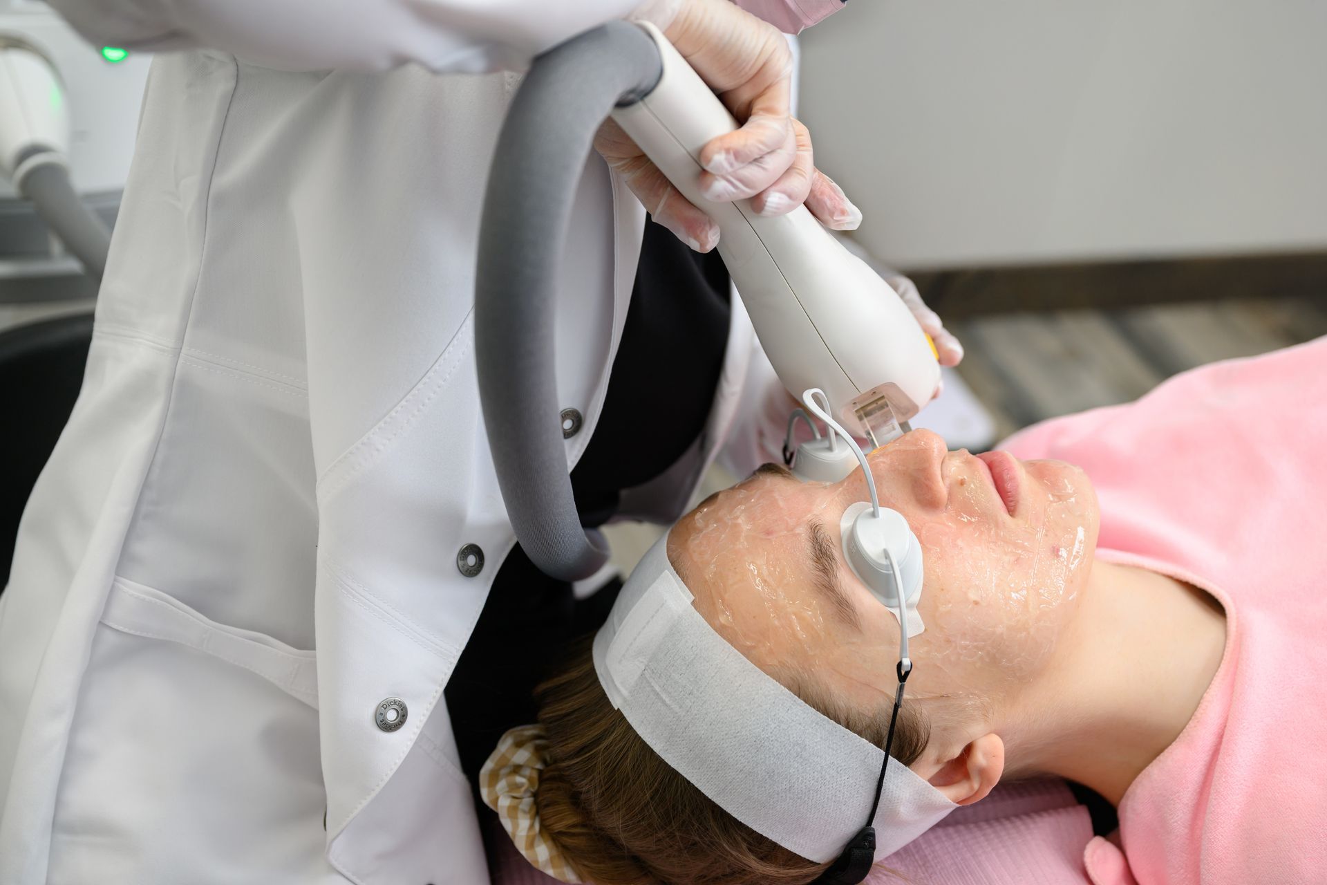 A woman is getting a laser treatment on her face.