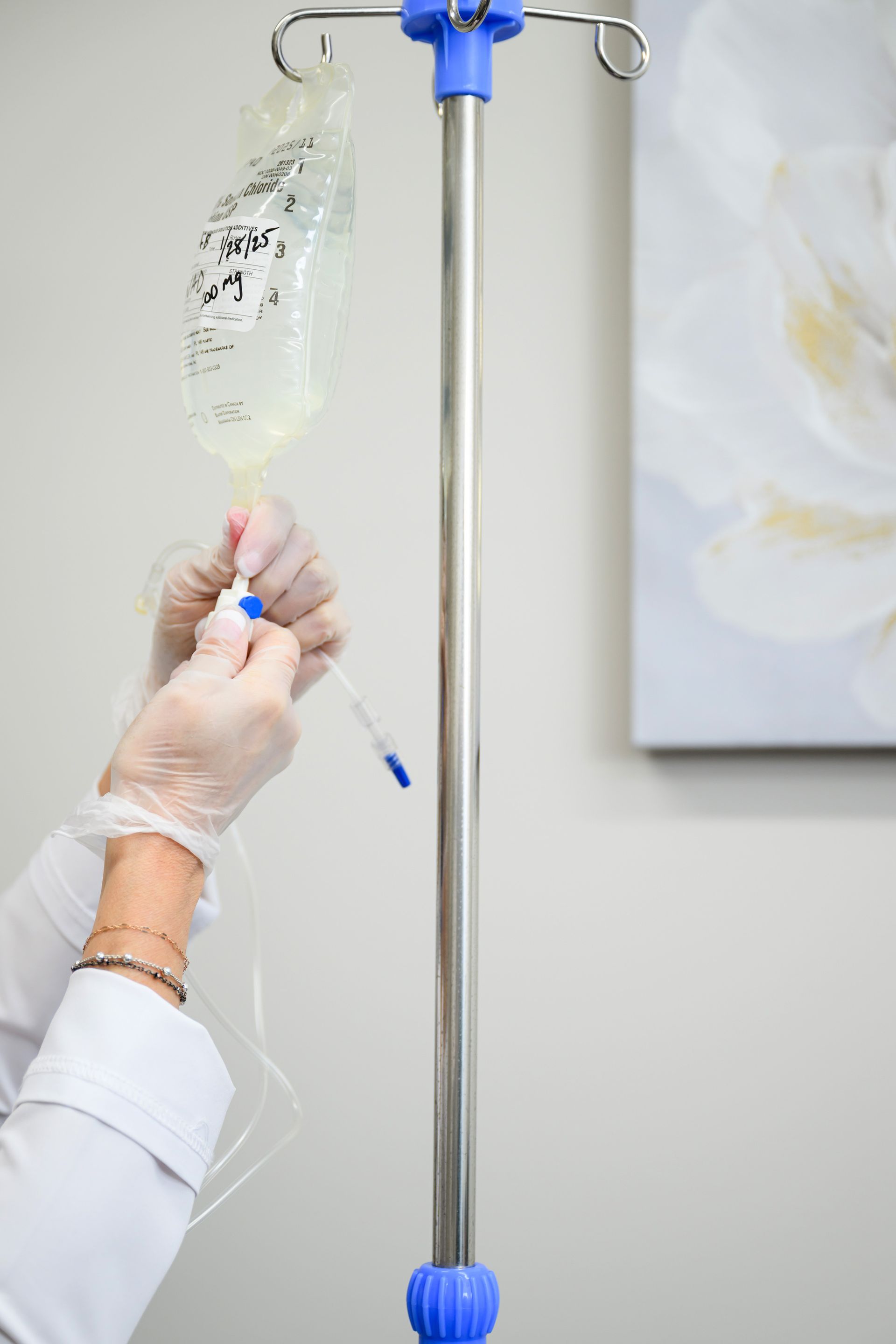 A person is holding a bag of liquid and a syringe.
