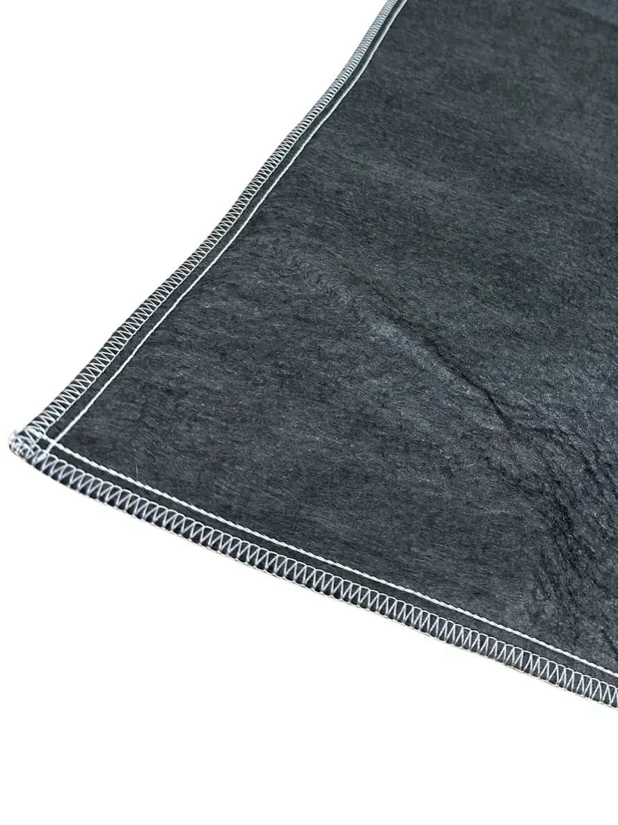 Black, irregularly shaped piece of fabric with a curved edge and a right-angled cut.