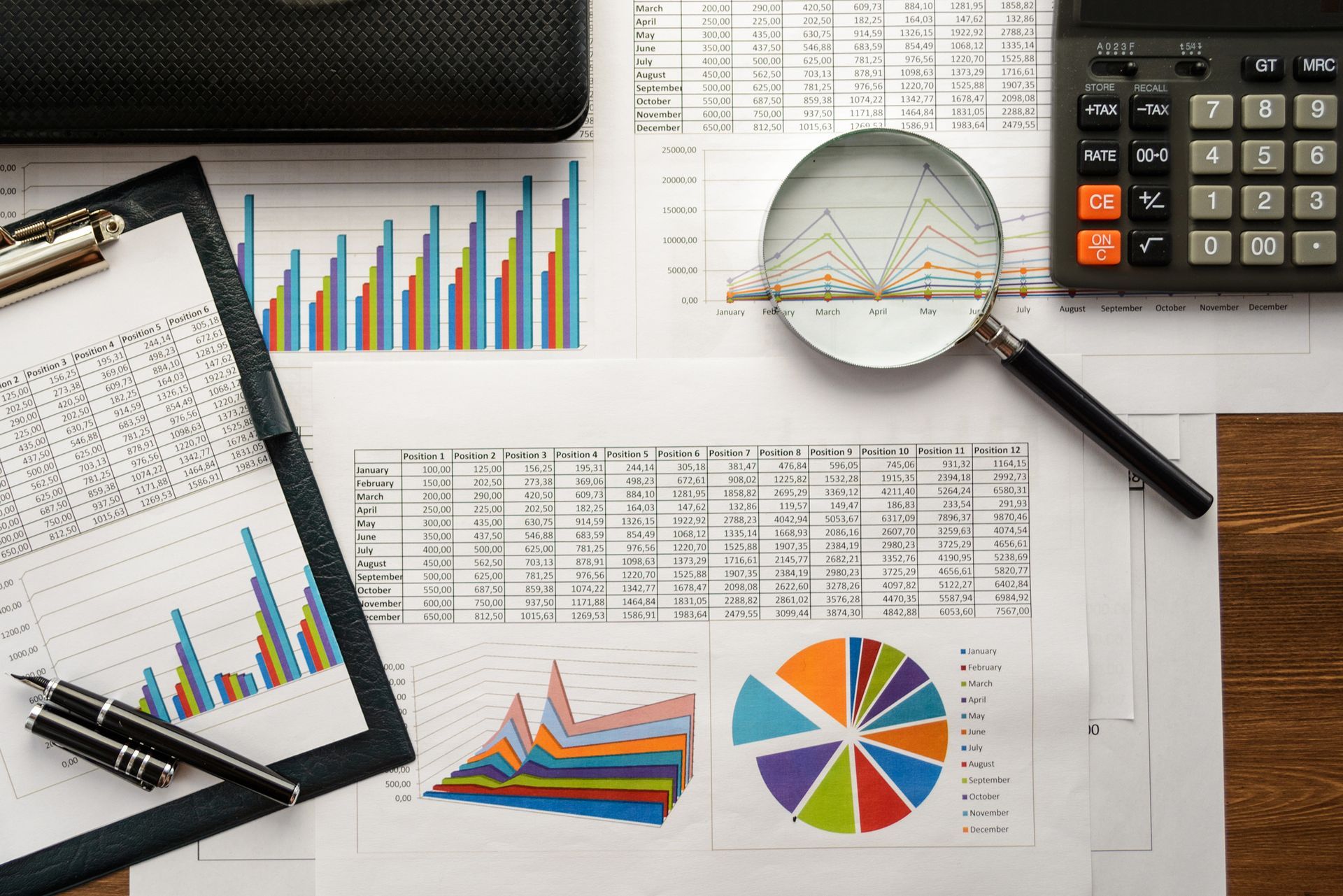 A calculator, financial documents, and a pen arranged on a desk, symbolising accounting tasks