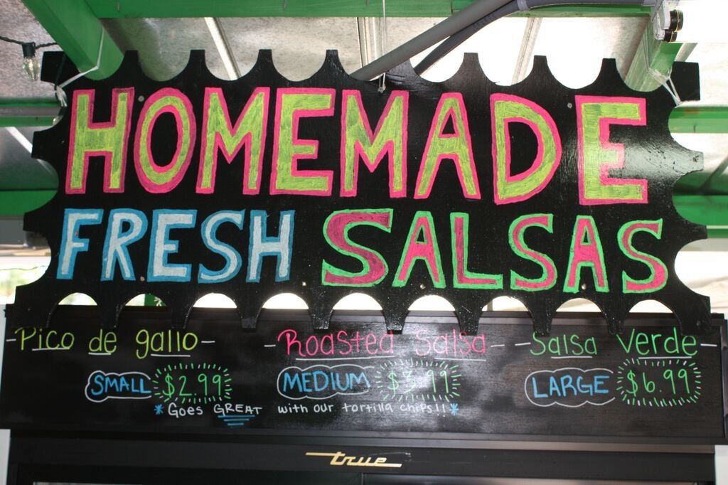 Black sign advertising homemade fresh salsas with price options.