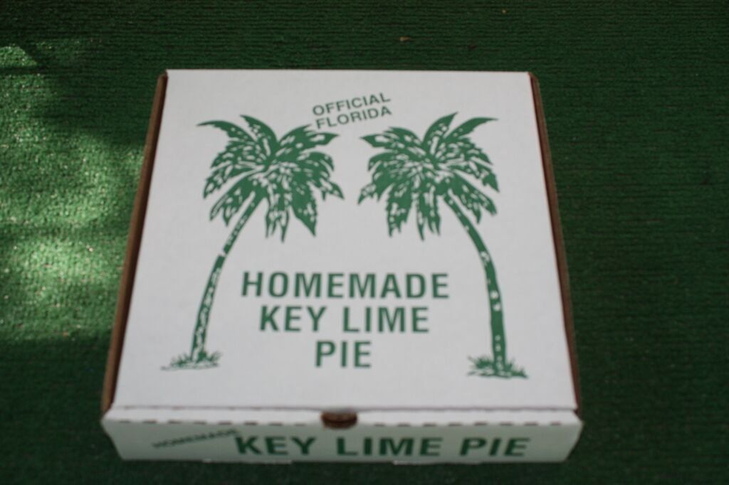 Box of homemade Key Lime Pie with green palm trees.