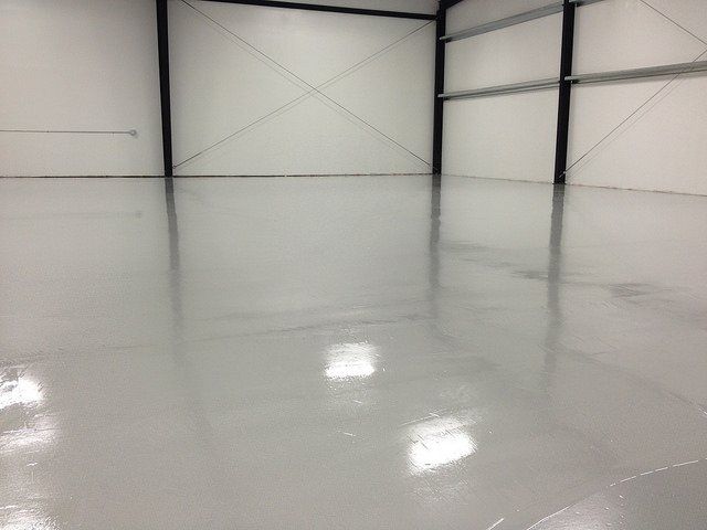 a large warehouse with a shiny concrete floor and white walls .