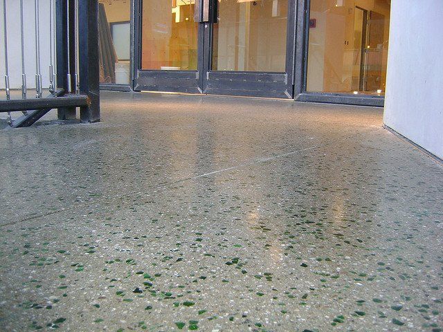 a concrete floor with a few green spots on it