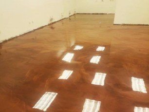 a room with a metallic epoxy floor and white walls .