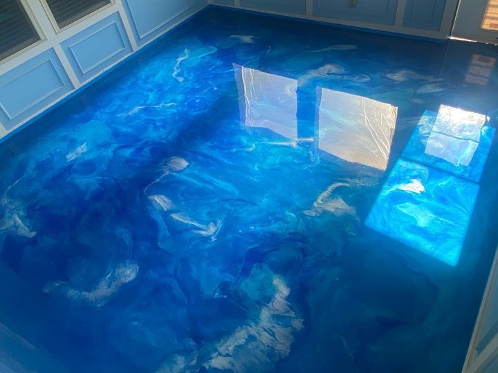 a blue floor with a reflection of a window in it .