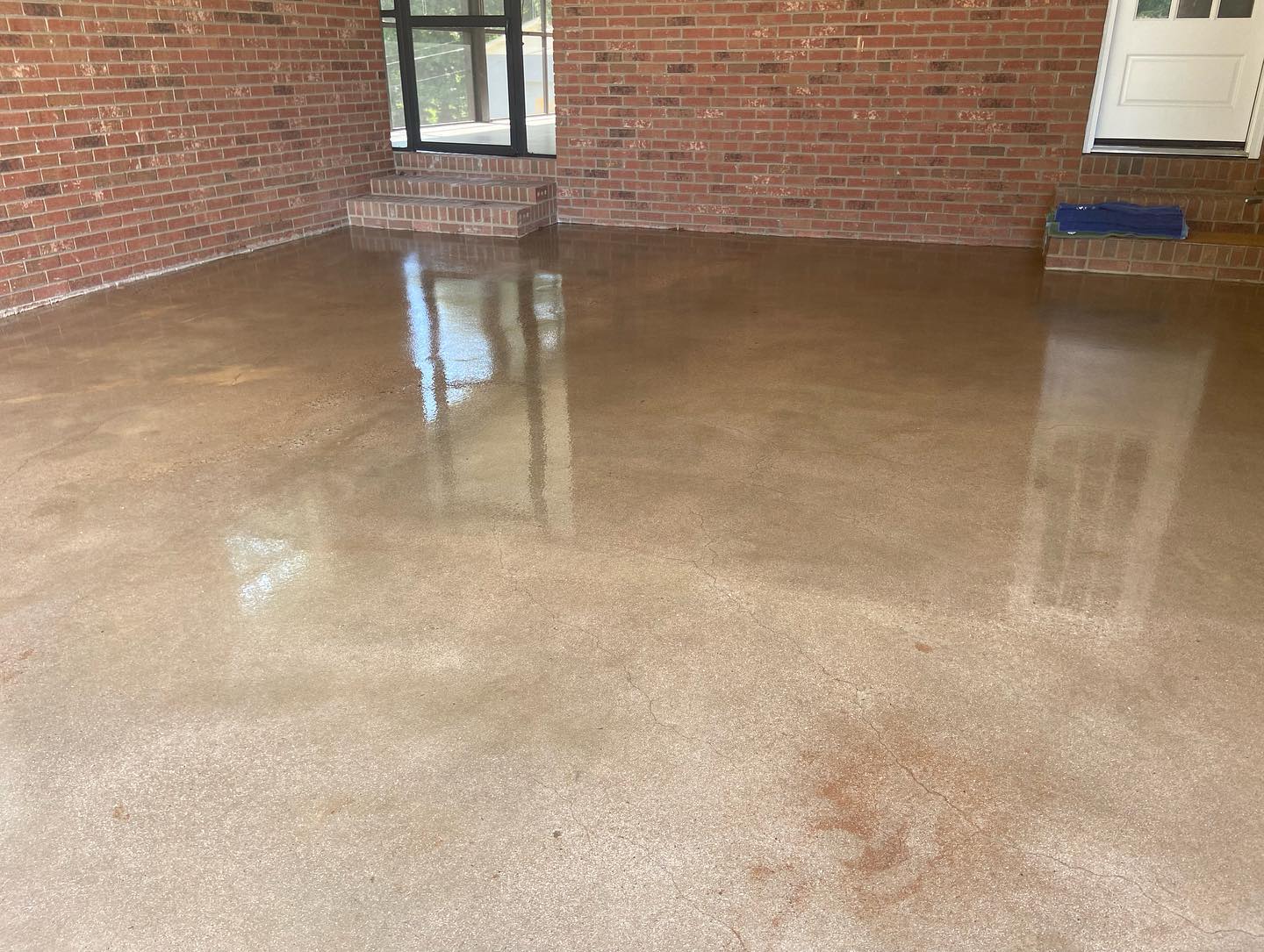 a concrete floor in a room with a brick wall .