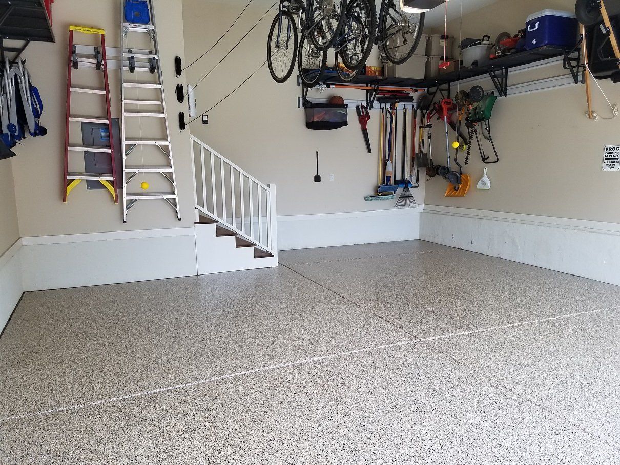 a epoxy garage floor with a ladder and bikes on the wall