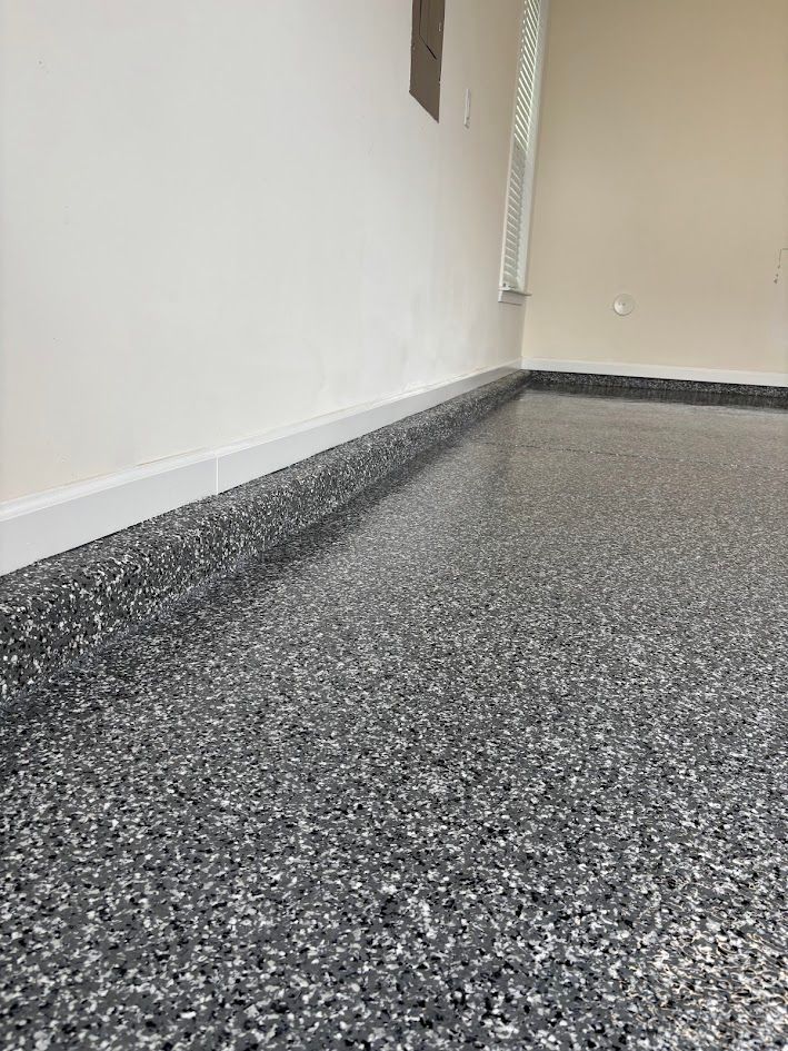 Garage with a speckled gray floor and white walls.