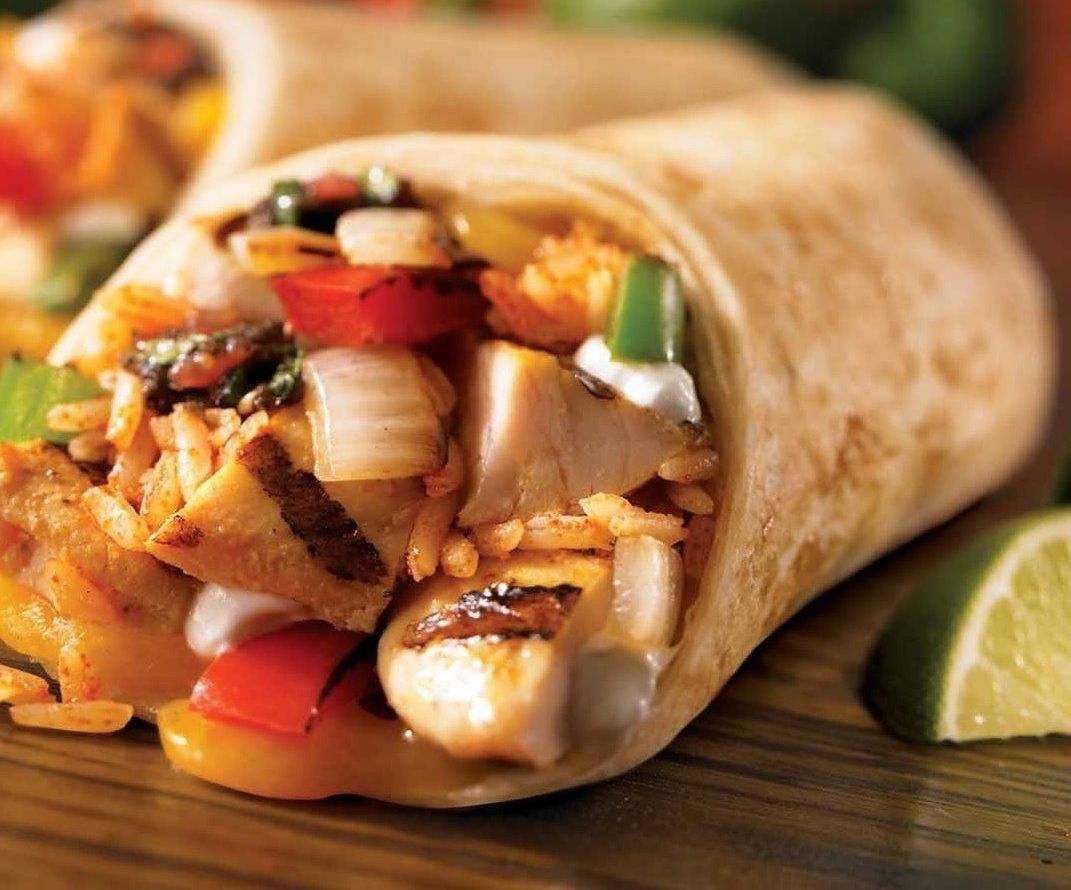 A Burrito With Chicken and Vegetables on a Wooden Table — The Larder Byron Bay in Byron Bay, NSW