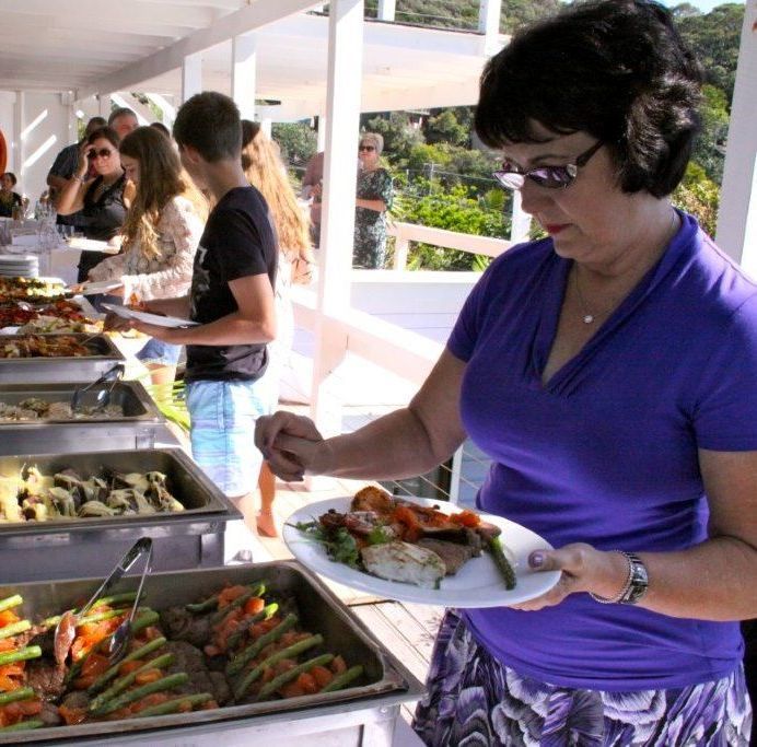 A Woman in a Purple Shirt is Taking a Plate of Food From a Buffet Line — The Larder Byron Bay in Byron Bay, NSW