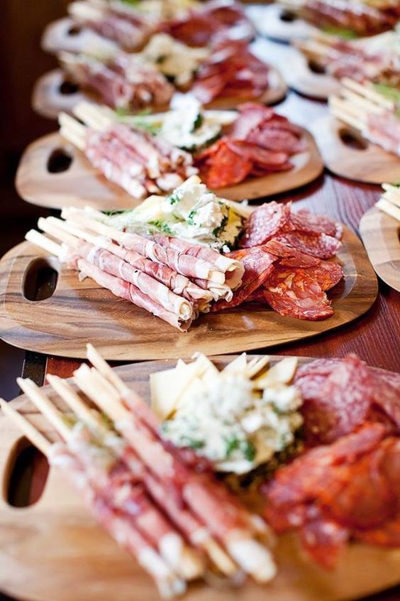 A variety of meats and cheeses on wooden cutting boards on a table  — The Larder Byron Bay in Byron Bay, NSW