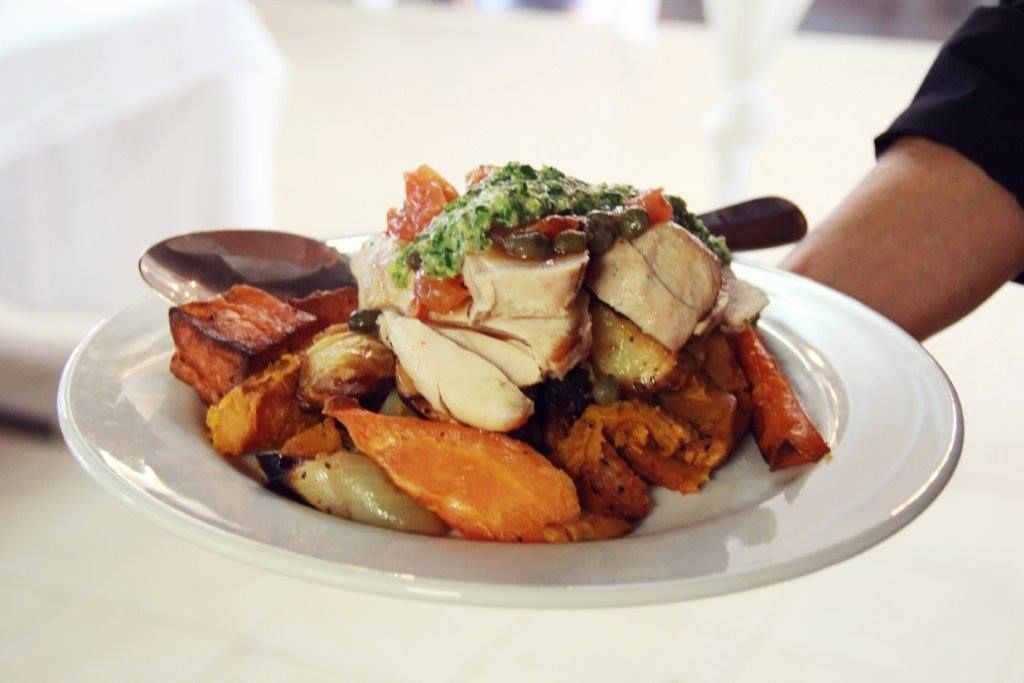 A Person is Holding a Plate of Food With a Spoon in It — The Larder Byron Bay in Byron Bay, NSW