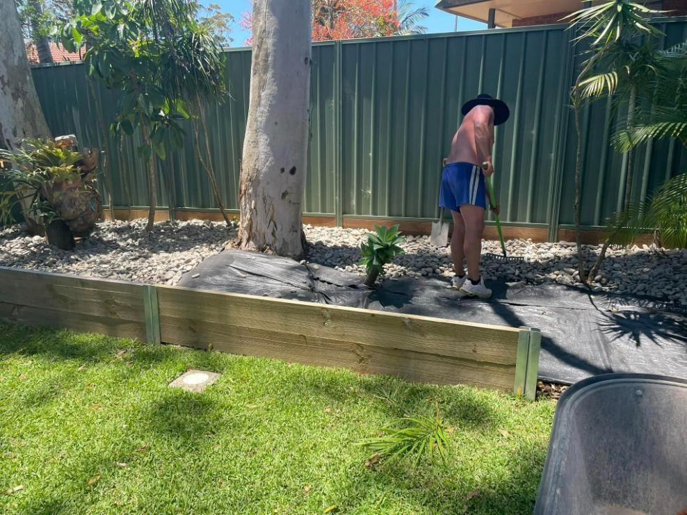 A Man Is Standing in A Yard with A Shovel and Rake — Port Tipper & Driver In Port Macquarie, NSW