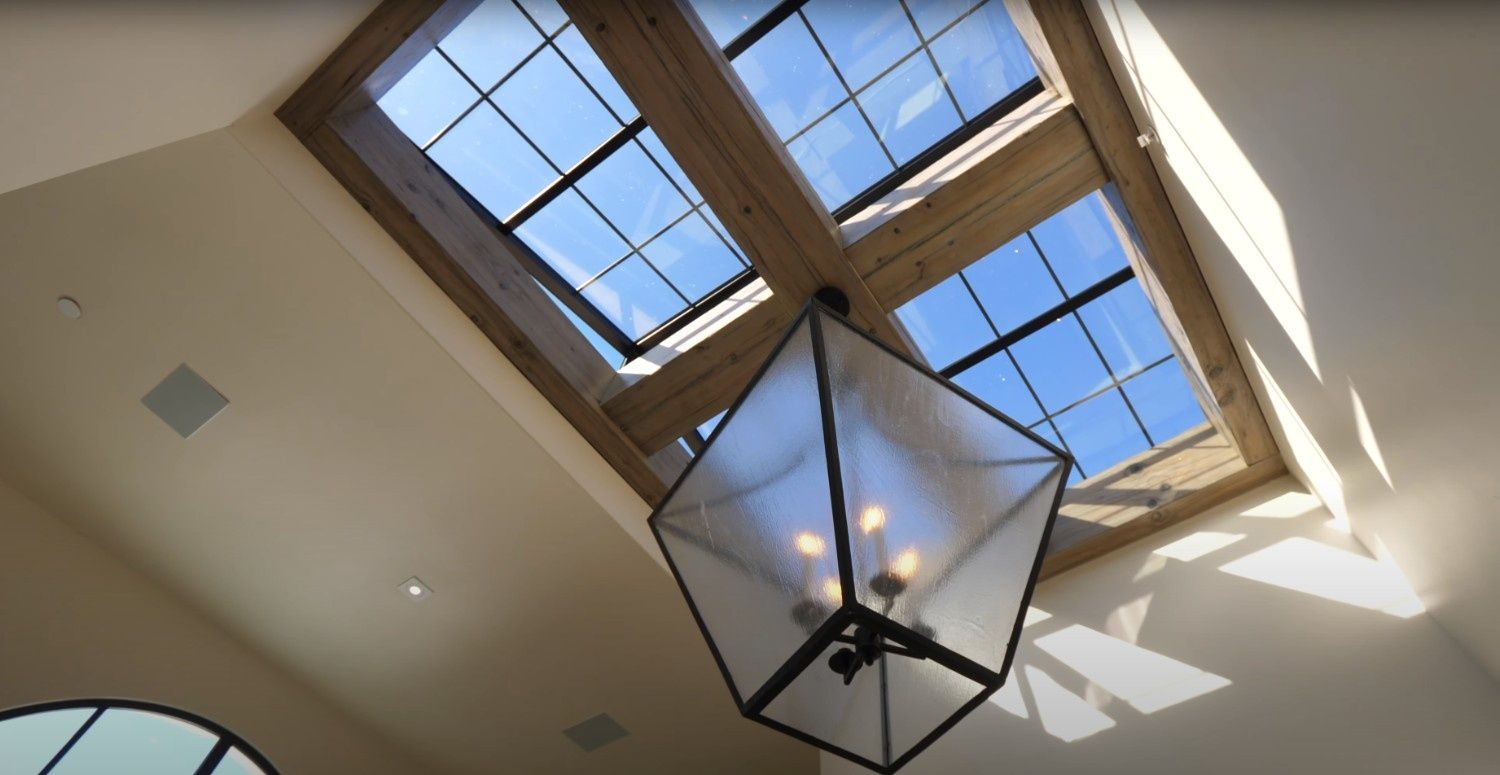 Looking up at a skylight with a chandelier hanging from it