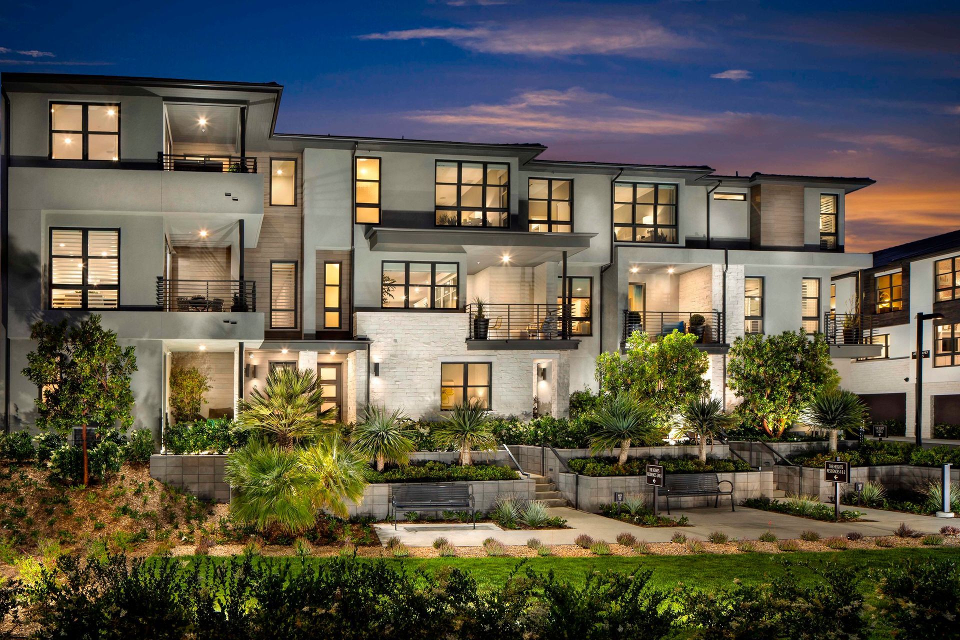 A large apartment building with lots of windows is lit up at night.