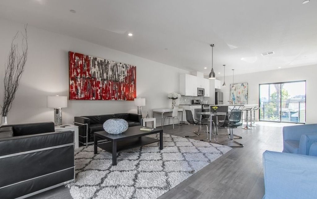 A living room filled with furniture and a painting on the wall.