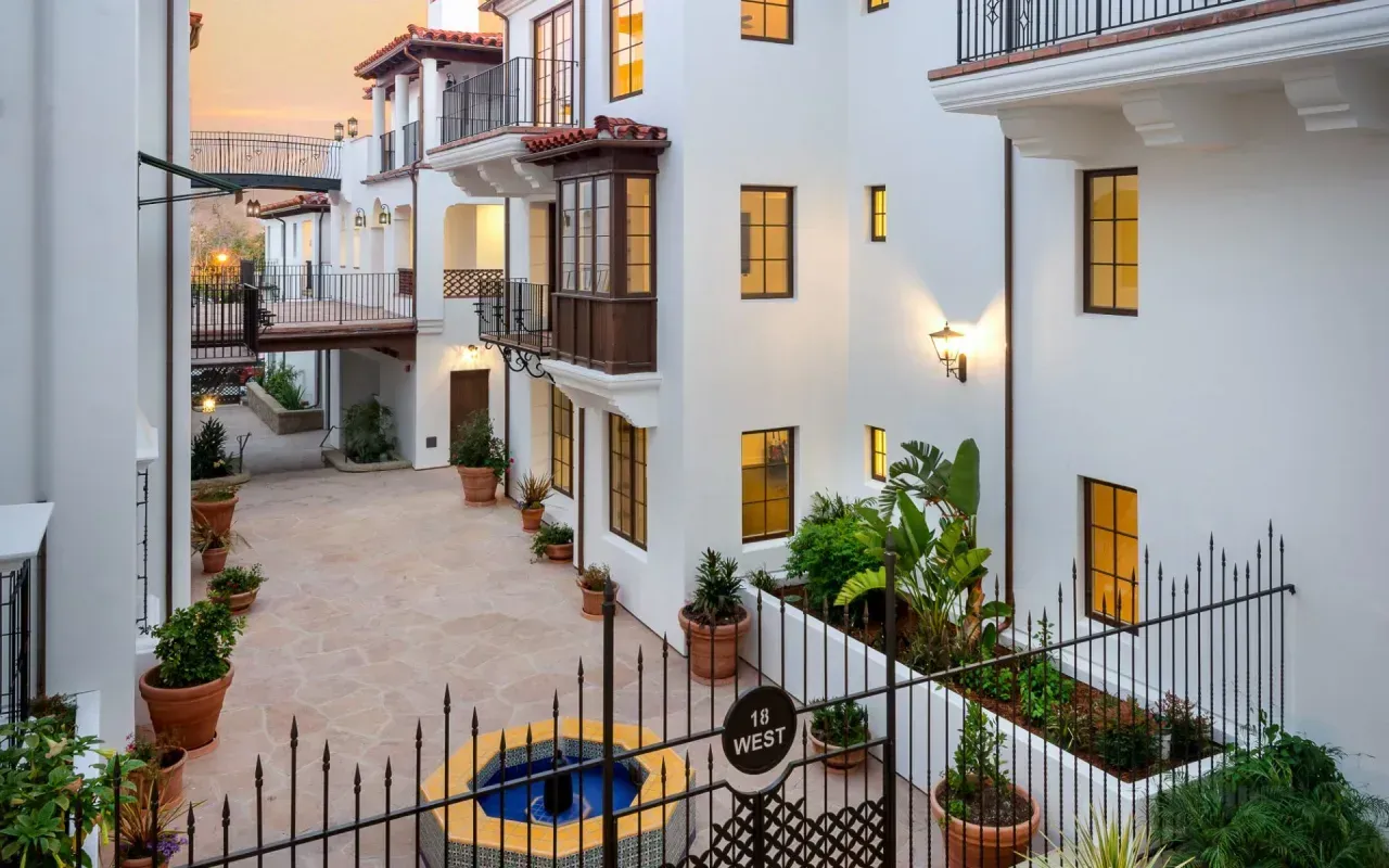 A white building with a fountain in the middle of it