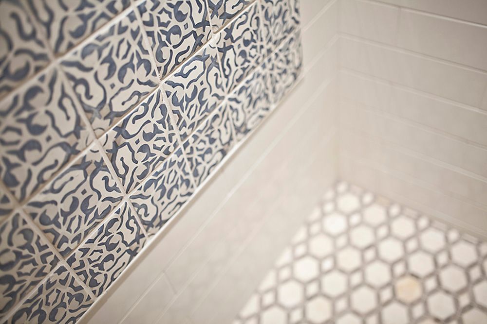 A bathroom with blue and white tiles on the wall and floor.