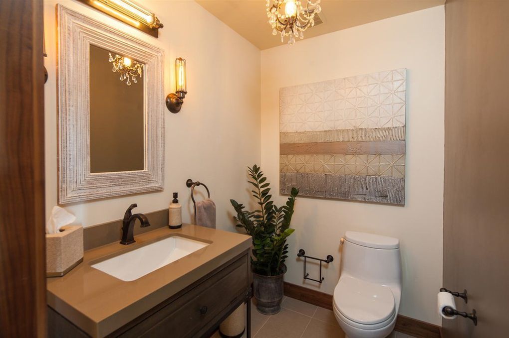 A bathroom with a toilet , sink and mirror.