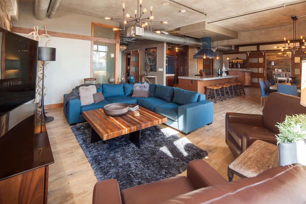 A living room with a blue sectional couch and a wooden coffee table.