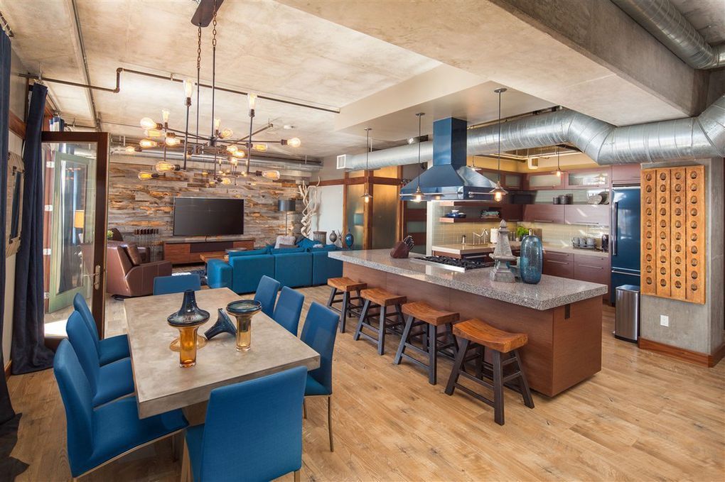 A large living room with a dining table and chairs and a kitchen.