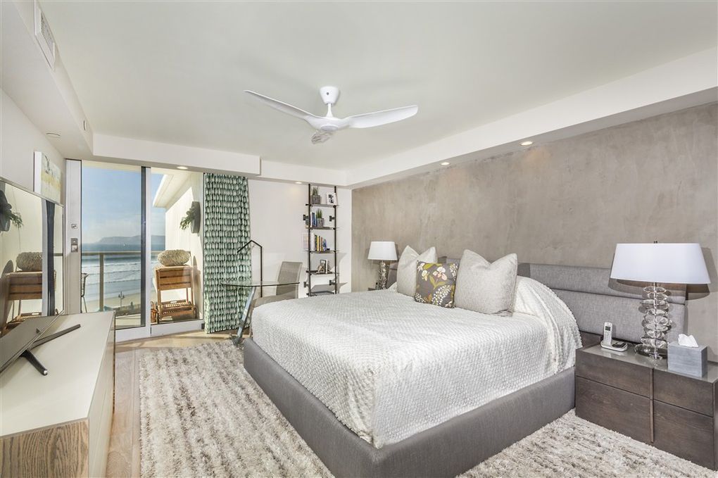 A bedroom with a large bed and a ceiling fan