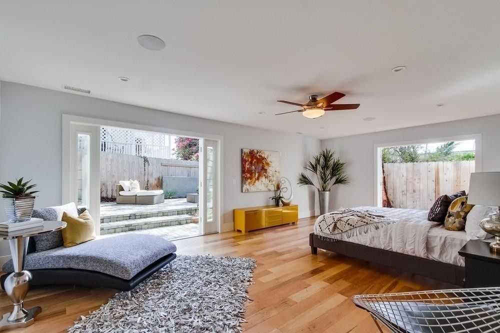 A bedroom with a large bed and a ceiling fan.