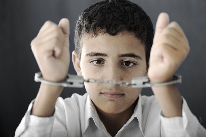 Kid with handcuffs on hands — Glen Burnie, MD — The Law Offices Of Fischer & Putzi, P.A.
