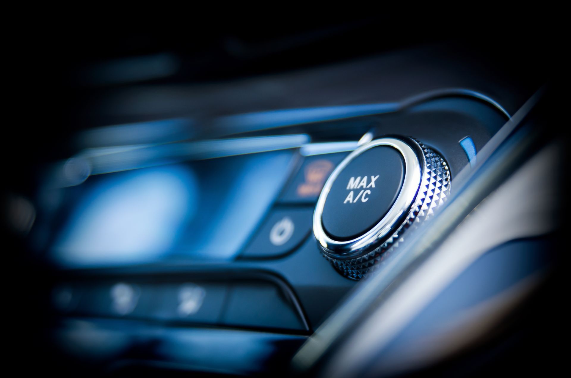 A close up of a car dashboard with a button that says max a / c.