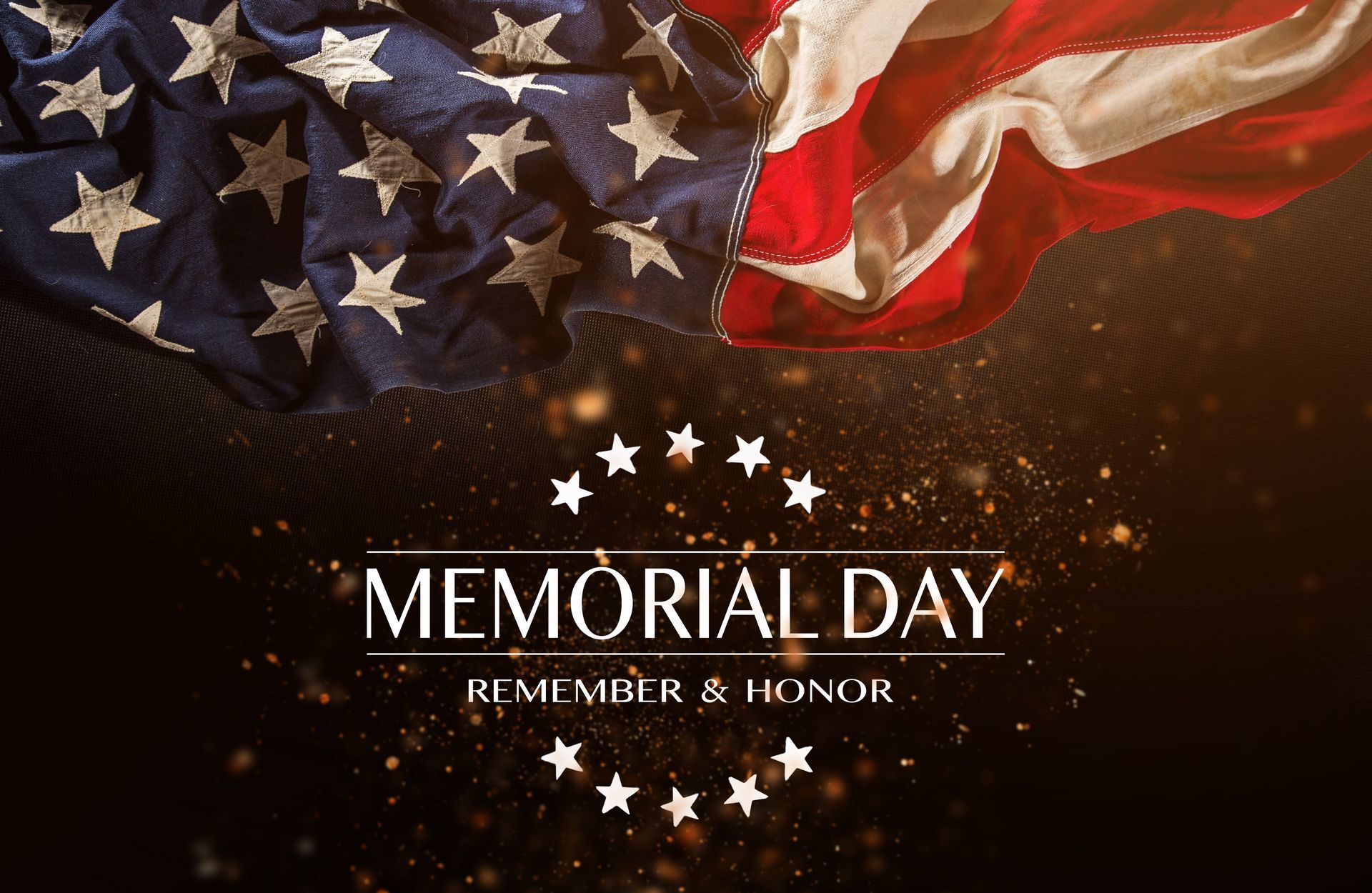 The american flag is waving in the wind on memorial day.