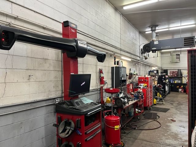 A red machine is sitting in the middle of a garage.