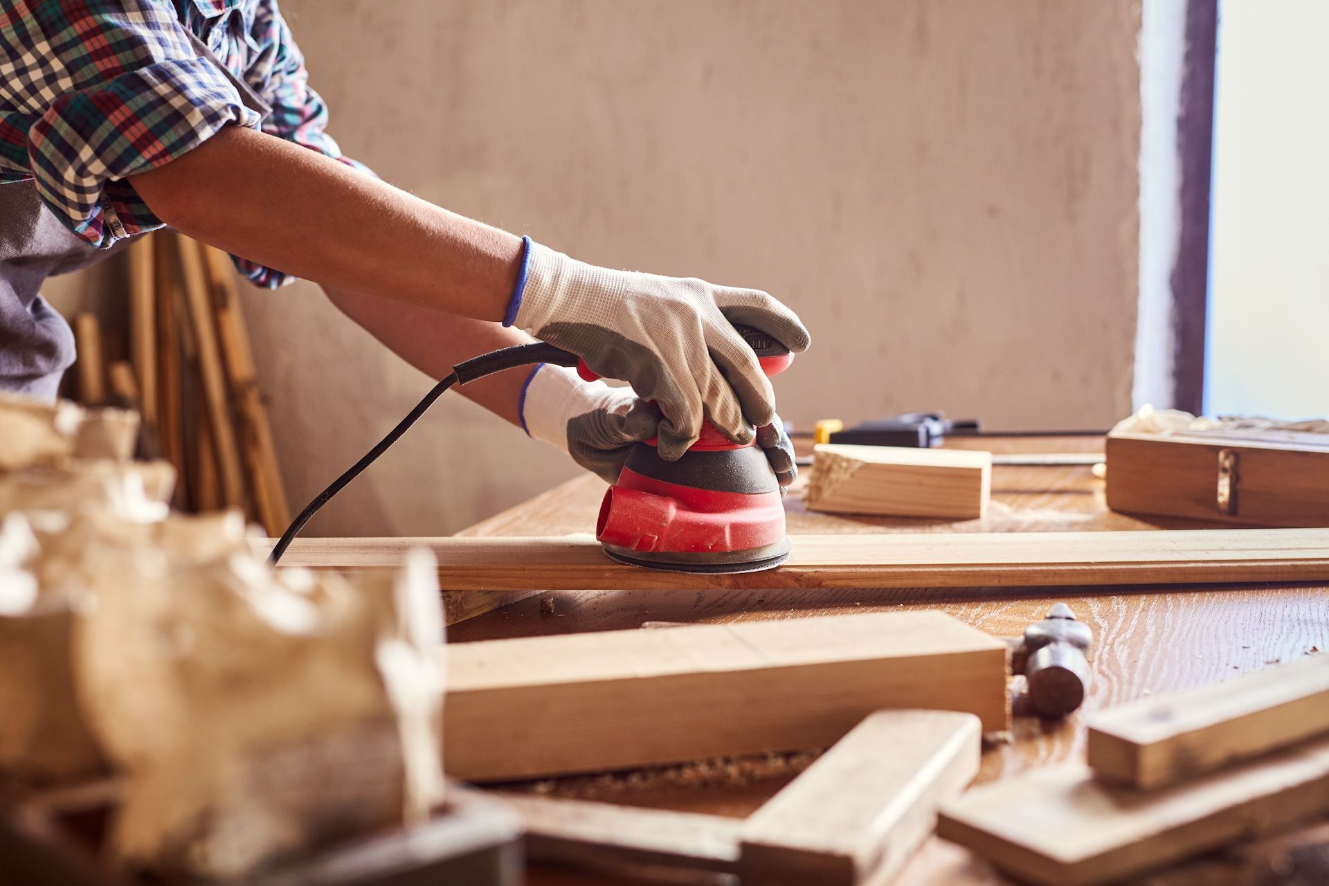 A man is sanding a piece of wood with a sander.