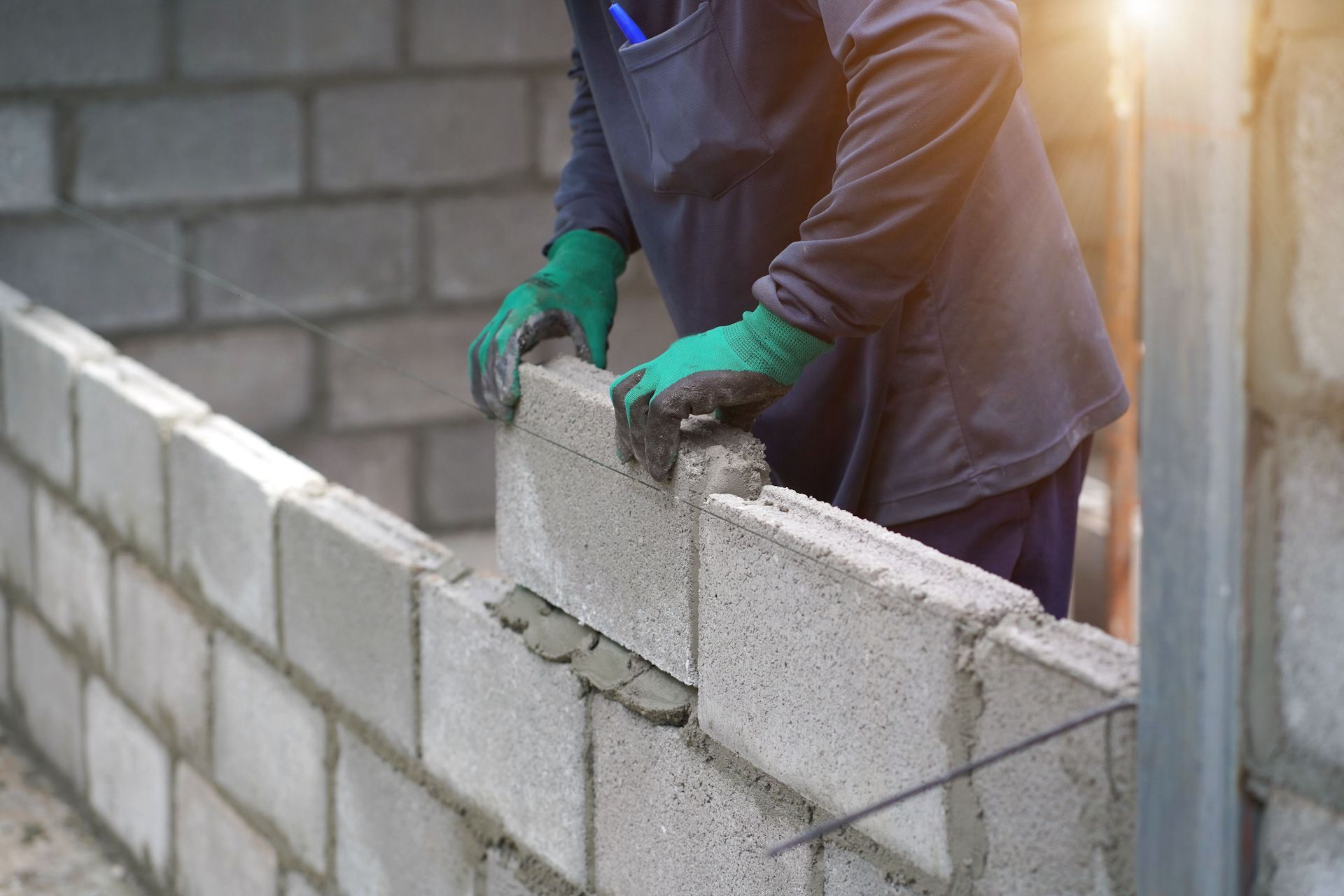 A man is building a brick wall on a construction site.