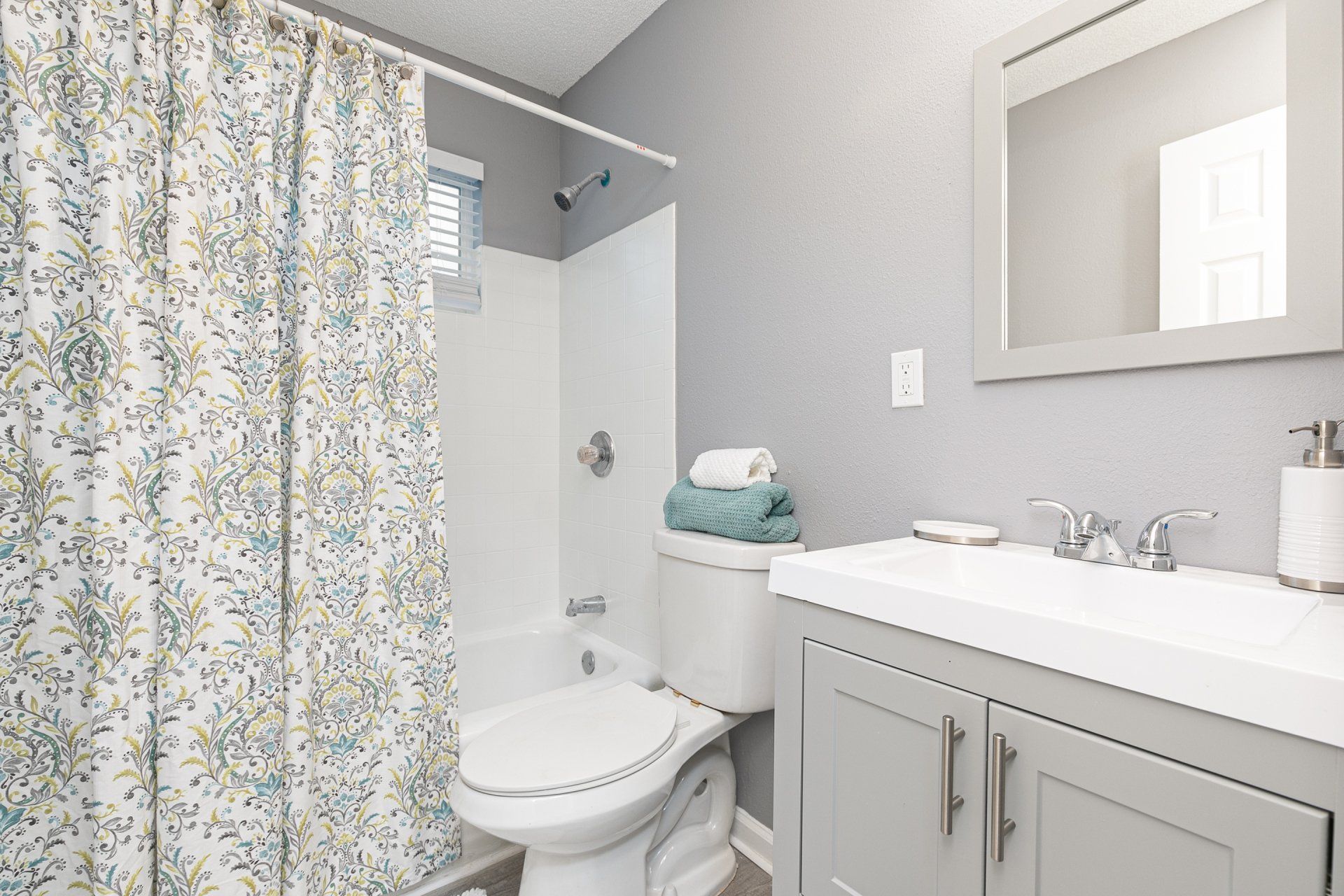 Pet-Friendly Apartments in Sylvan Hills, GA - Gateway South Apartments - Bathroom with White Countertops, Grey Cabinets, and Shower/Tub Combo